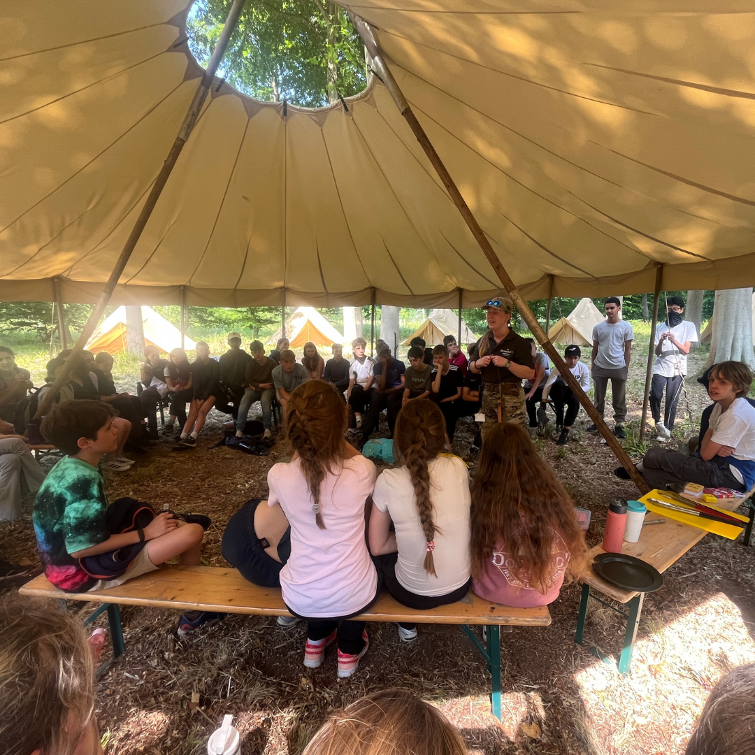 Image of students in a tent to illustrate link to 'Residential Trips' page